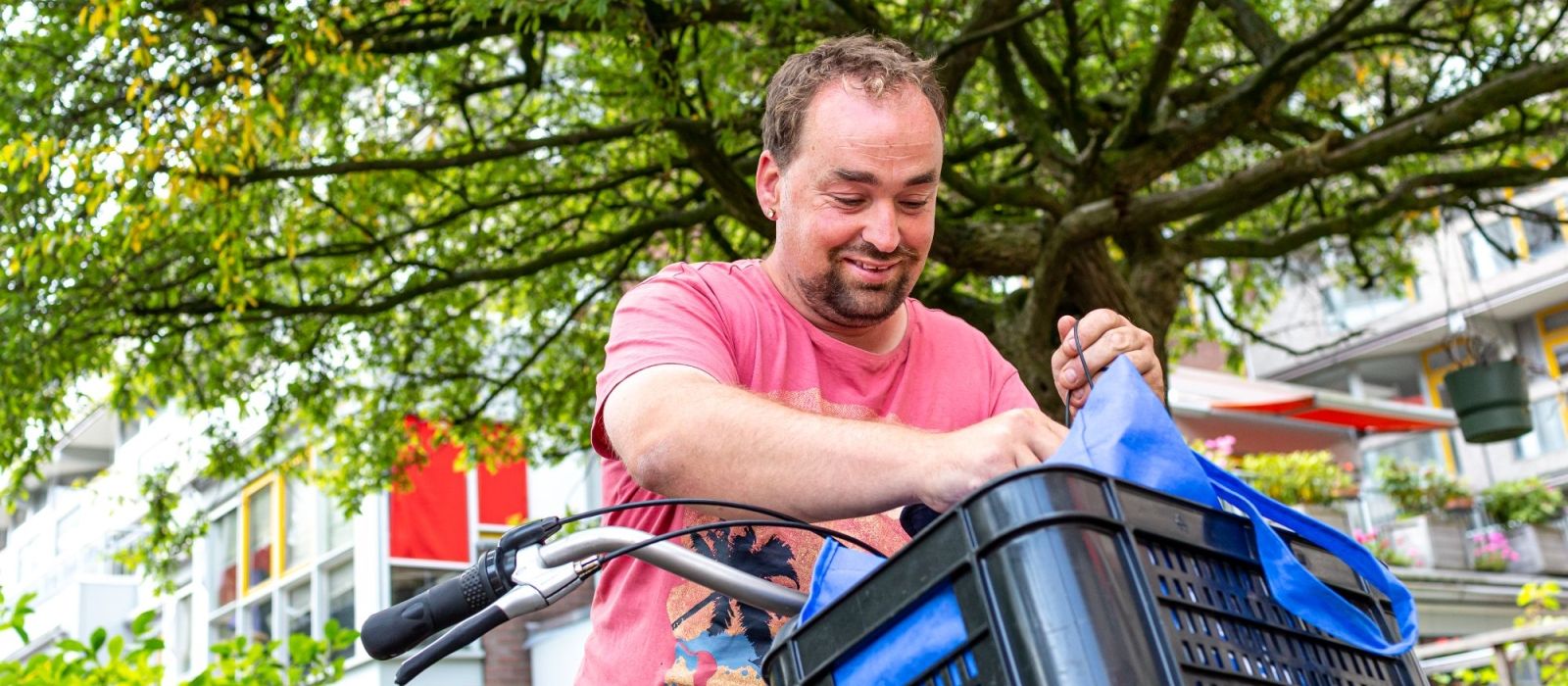 Jonge man doet boodschappen in zijn fietskrat