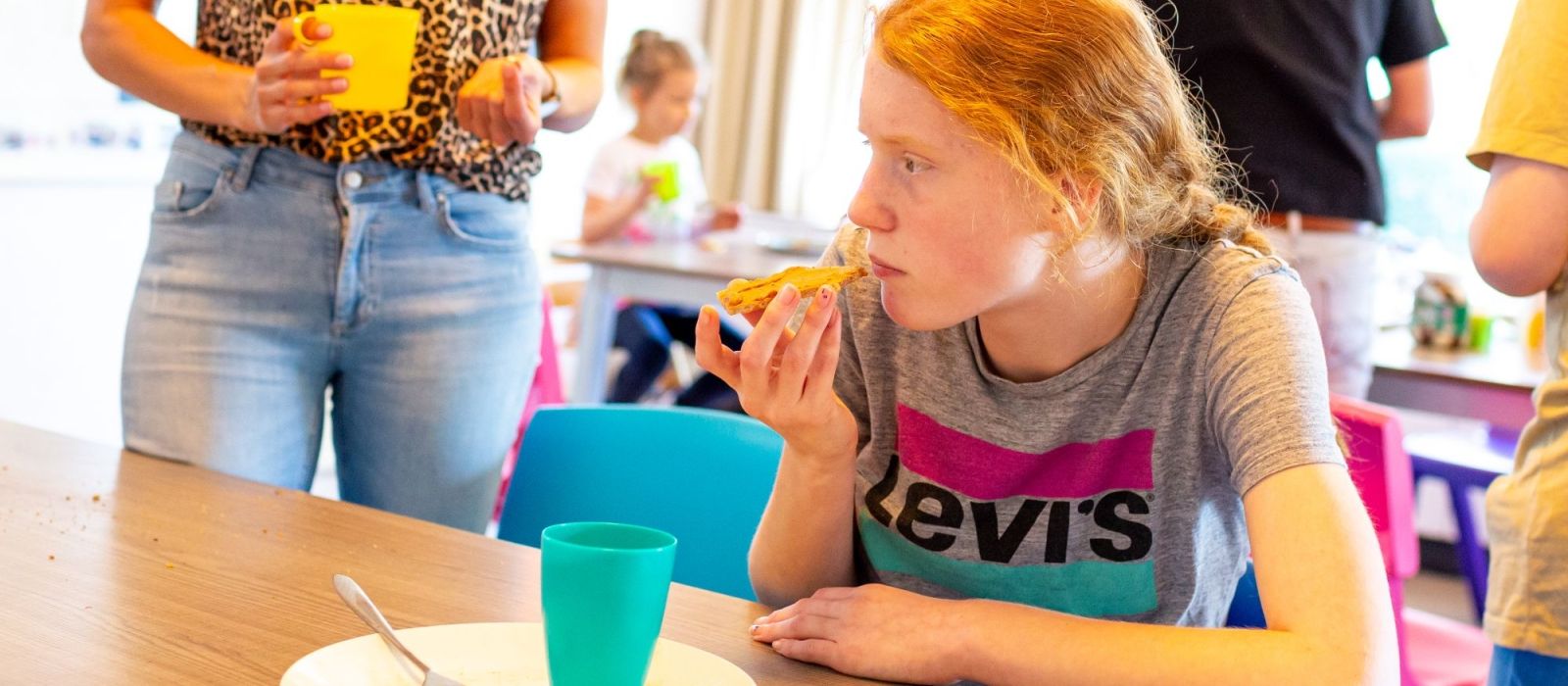 Jonge cliënt is aan tafel aan het eten en drinken