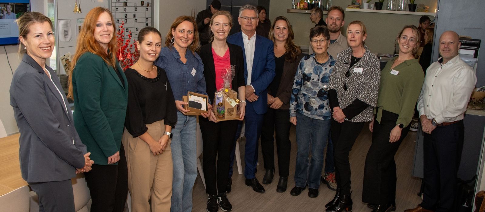 Staatssecretaris Nicki Pouw-Verweij staat temidden van een groep met medewerkers van zorgorganisatie Ipse de Bruggen