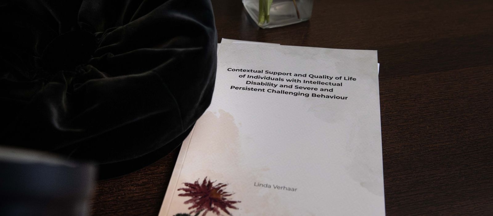 Proefschrift ligt op een houten tafel met de titel erop