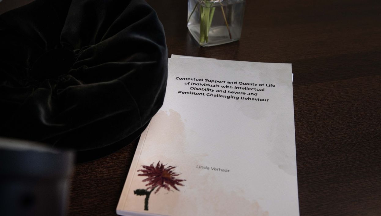 Proefschrift ligt op een houten tafel met de titel erop