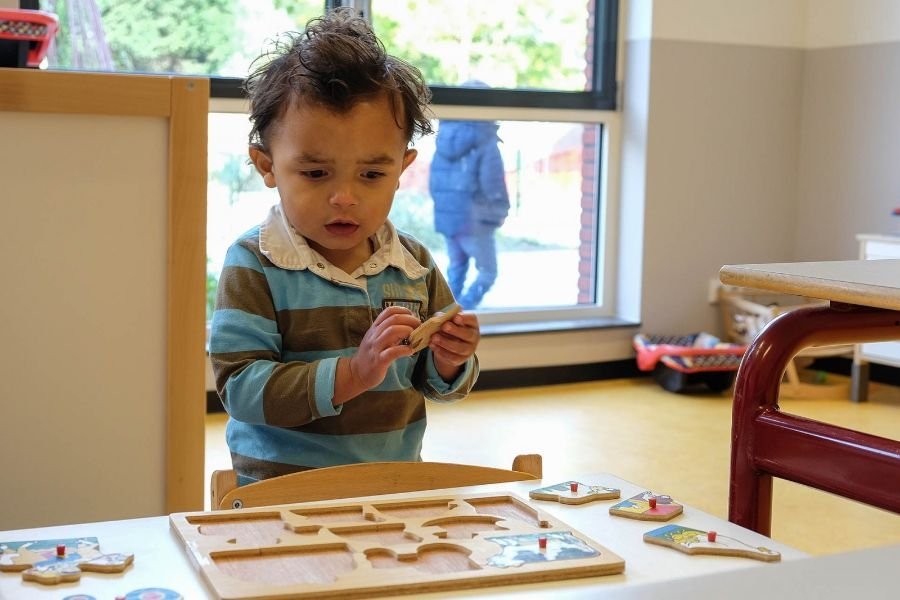 Jongetje aan het puzzelen op de De Kleurentuin