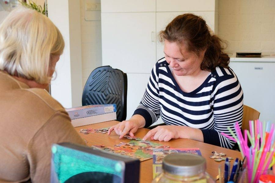 Clienten maken een puzzel bij dagbesteding Woutershof Willemshoevelaan in Spijkenisse