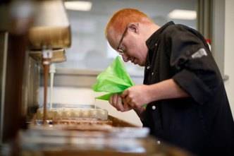 Medewerker van de Choko Toko is chocolaatjes aan het maken